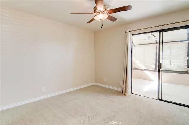 spare room featuring a ceiling fan, light carpet, and baseboards