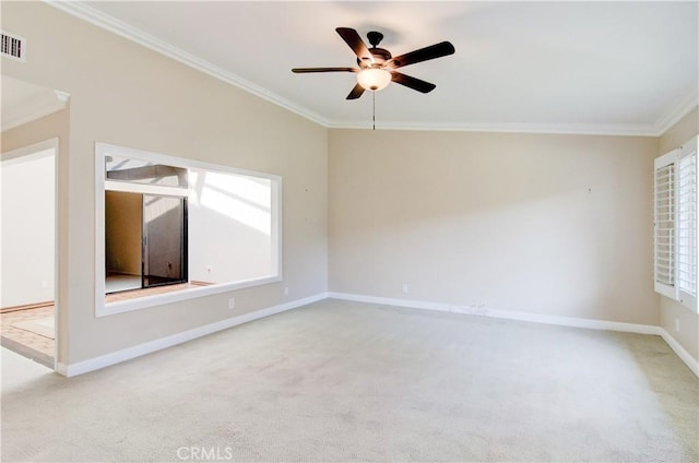 spare room with ceiling fan, light carpet, visible vents, baseboards, and crown molding