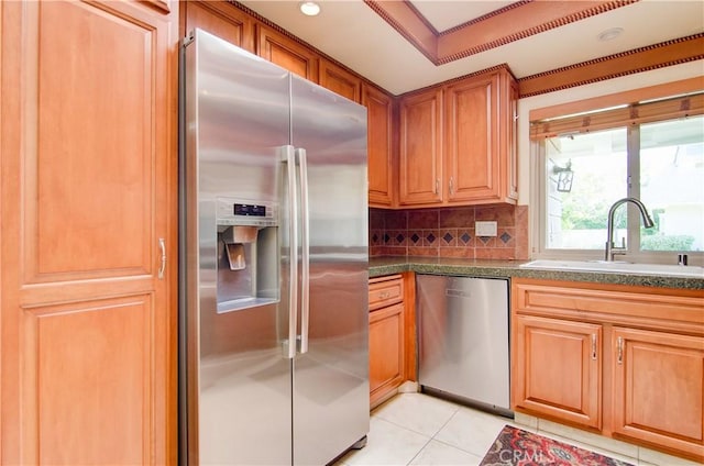 kitchen with dark countertops, tasteful backsplash, stainless steel appliances, and a sink