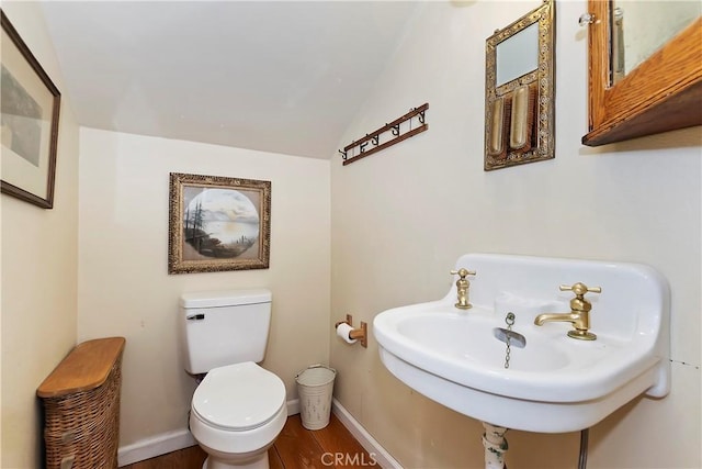 bathroom with lofted ceiling, sink, hardwood / wood-style floors, and toilet