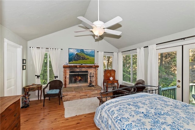 bedroom featuring a fireplace, lofted ceiling, access to outside, ceiling fan, and light hardwood / wood-style floors