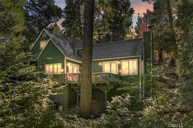 back house at dusk with a deck