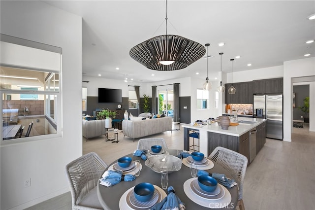 dining space with sink and light hardwood / wood-style flooring