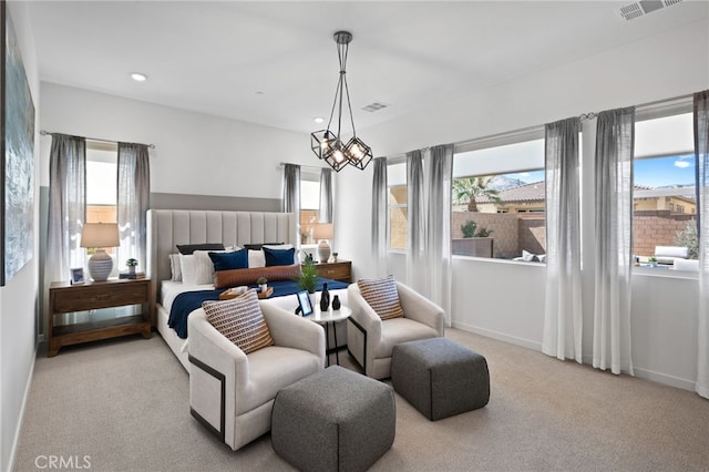 bedroom with light carpet and an inviting chandelier