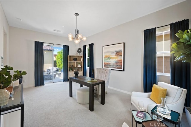 carpeted home office with an inviting chandelier