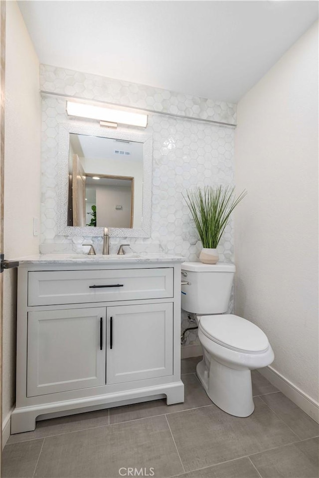 bathroom featuring vanity, tile patterned floors, and toilet