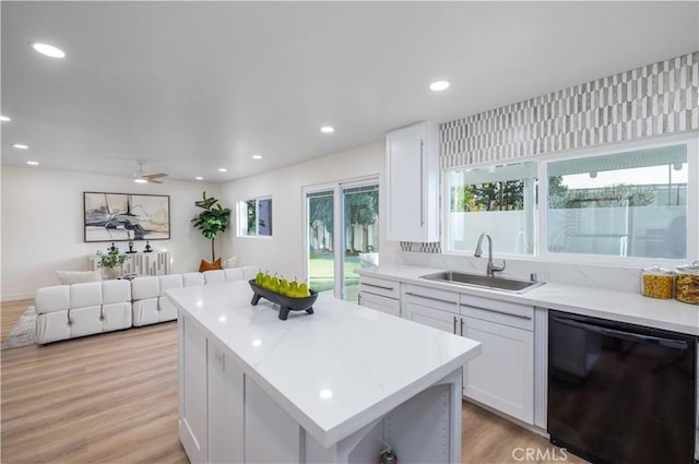 kitchen featuring sink, a center island, plenty of natural light, black dishwasher, and white cabinets