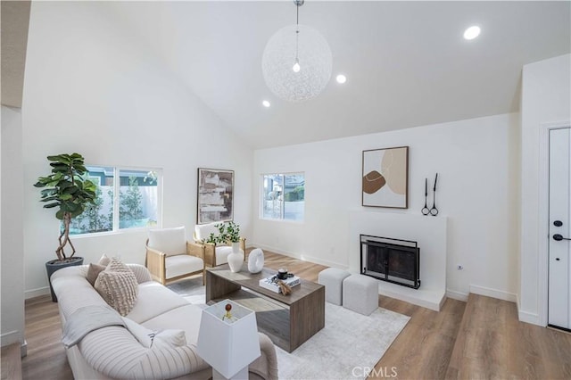 living room featuring high vaulted ceiling and light wood-type flooring