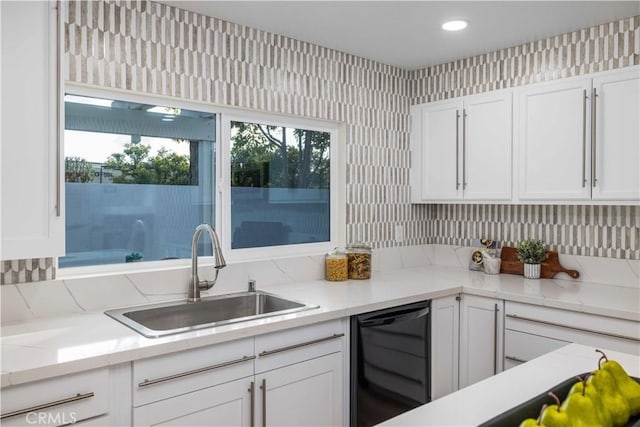 kitchen featuring white cabinetry, black dishwasher, and sink