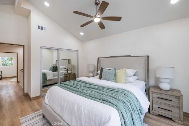 bedroom featuring ceiling fan, high vaulted ceiling, a closet, and light hardwood / wood-style flooring