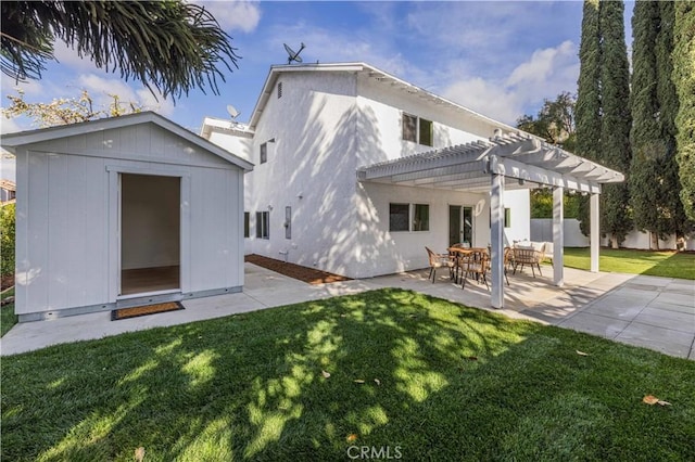 rear view of property with a storage shed, a pergola, a patio area, and a yard