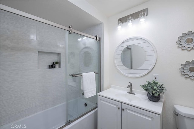 full bathroom with enclosed tub / shower combo, vanity, and toilet