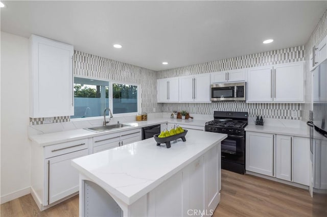 kitchen featuring white cabinetry, sink, and black appliances