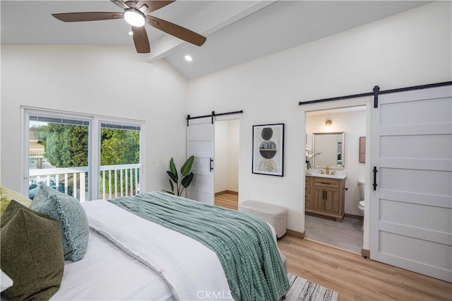 bedroom with ceiling fan, access to exterior, vaulted ceiling with beams, ensuite bathroom, and a barn door