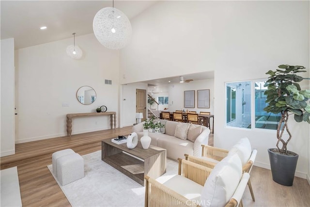 living room featuring light hardwood / wood-style flooring and high vaulted ceiling