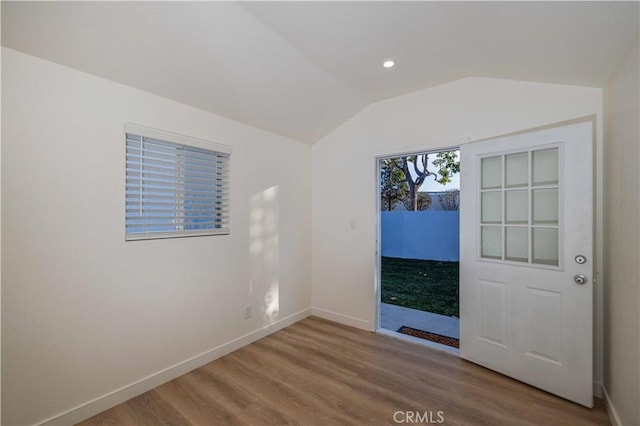 unfurnished room featuring lofted ceiling and hardwood / wood-style flooring