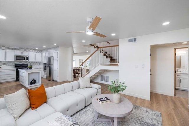 living room featuring ceiling fan and light wood-type flooring