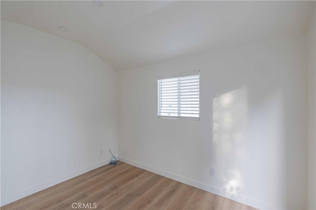 empty room with lofted ceiling and light hardwood / wood-style flooring