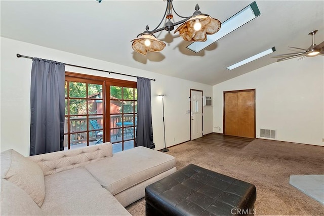 carpeted living room with ceiling fan, a wall mounted AC, and vaulted ceiling with skylight