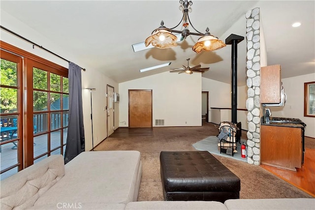 carpeted living room with vaulted ceiling and a wood stove