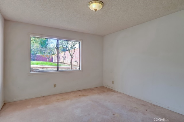 carpeted empty room featuring a textured ceiling