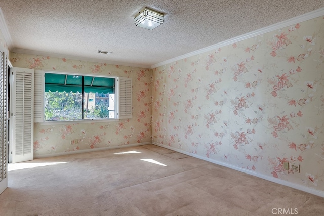 spare room with light colored carpet, ornamental molding, and a textured ceiling