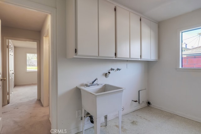 laundry area featuring gas dryer hookup, sink, and cabinets