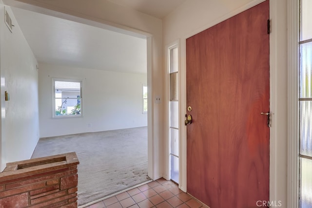 entryway featuring light colored carpet