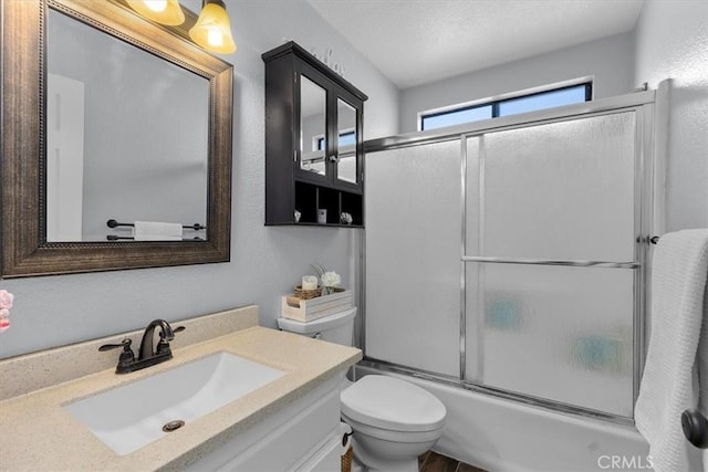 full bathroom with enclosed tub / shower combo, vanity, a textured ceiling, and toilet