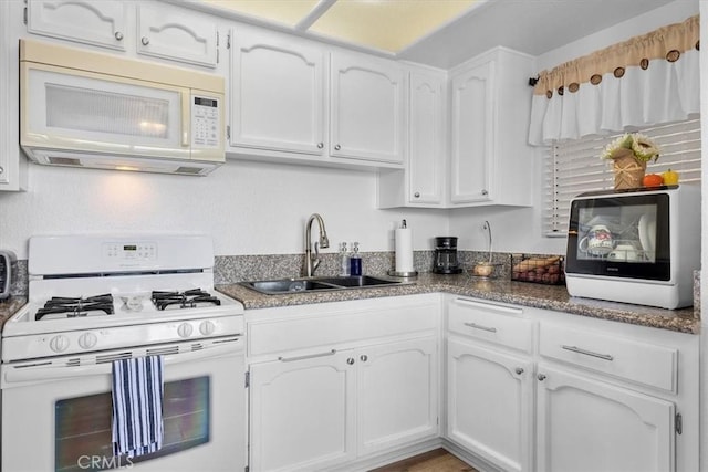 kitchen featuring white appliances, sink, and white cabinets