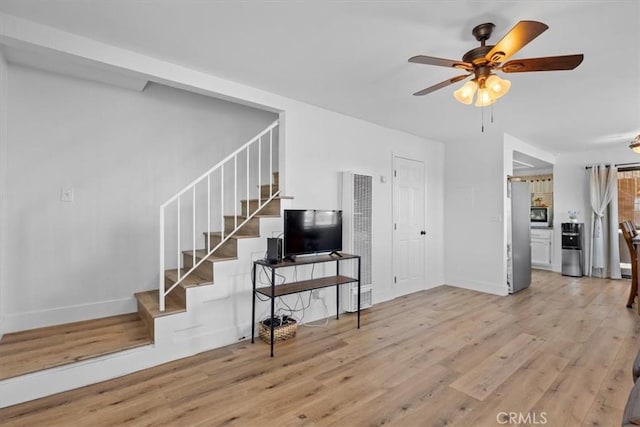 living room featuring ceiling fan and light hardwood / wood-style floors