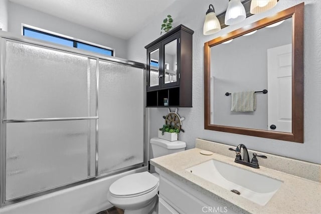 full bathroom with enclosed tub / shower combo, vanity, and toilet