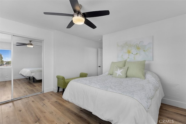 bedroom with hardwood / wood-style flooring, ceiling fan, and a closet