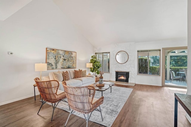 living room with hardwood / wood-style flooring, a fireplace, and high vaulted ceiling