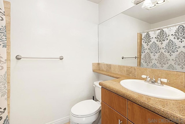 bathroom featuring tasteful backsplash, vanity, and toilet