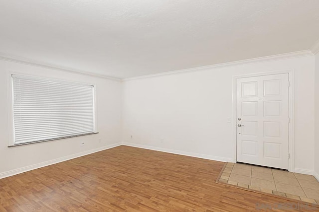 empty room featuring light hardwood / wood-style flooring and ornamental molding