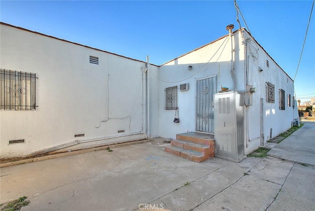 back of house featuring a wall mounted AC and a patio