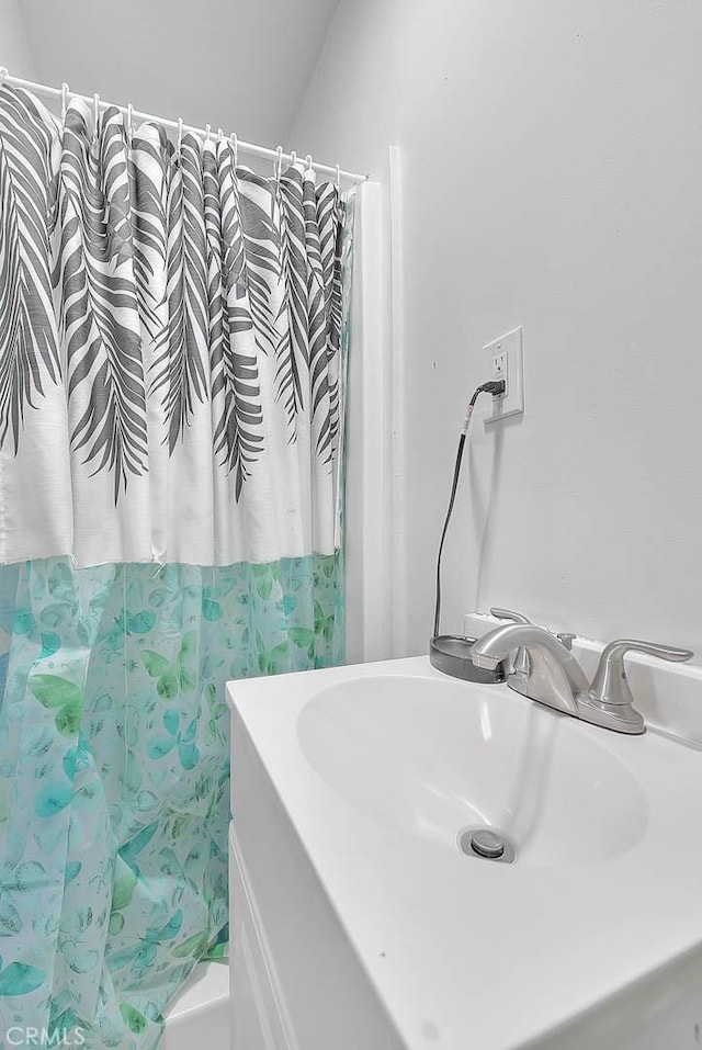 bathroom with sink and shower / bath combo with shower curtain