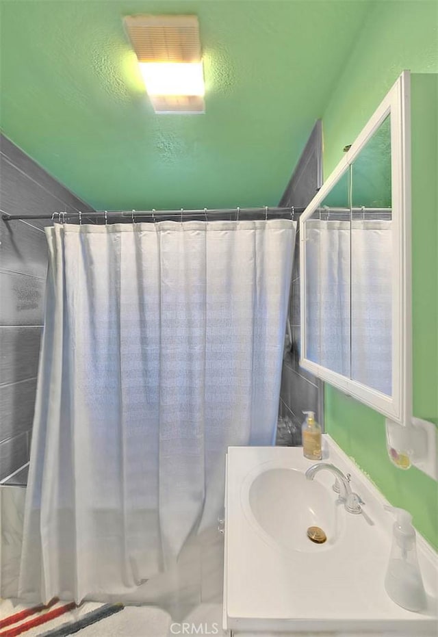 bathroom featuring a shower with curtain and sink