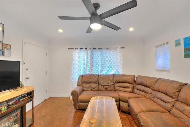 living room featuring light hardwood / wood-style flooring and ceiling fan