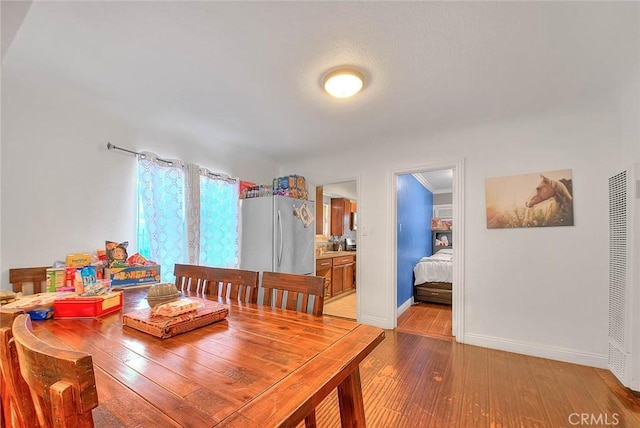 dining area with crown molding and light hardwood / wood-style flooring