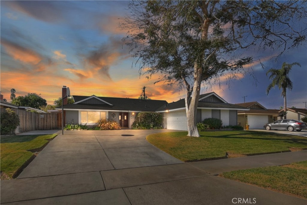 ranch-style house with a garage and a lawn