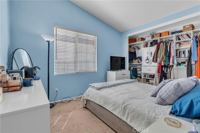 carpeted bedroom featuring vaulted ceiling and a closet