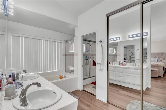 bathroom featuring hardwood / wood-style flooring, vanity, and separate shower and tub