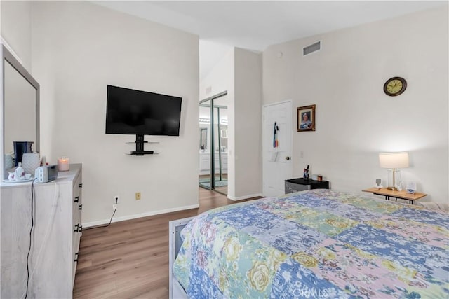 bedroom featuring light hardwood / wood-style flooring and high vaulted ceiling