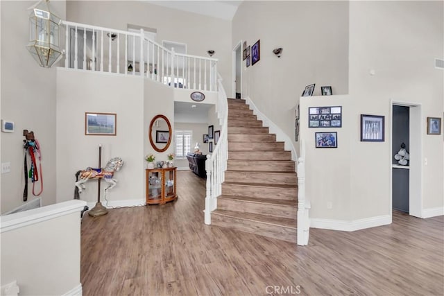 staircase featuring hardwood / wood-style flooring and a high ceiling