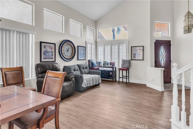 living room featuring high vaulted ceiling and hardwood / wood-style floors