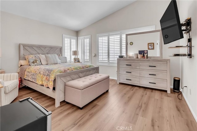 bedroom featuring lofted ceiling and light hardwood / wood-style flooring