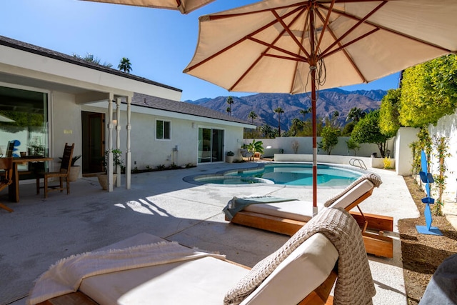 view of swimming pool featuring a mountain view and a patio