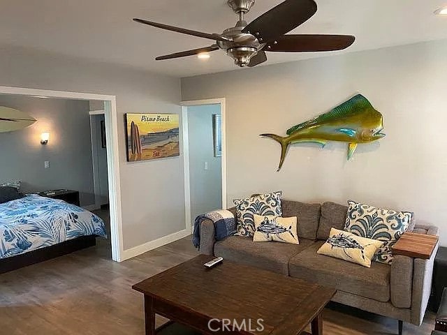 living room featuring dark hardwood / wood-style flooring and ceiling fan